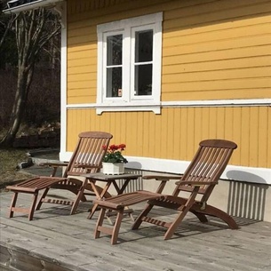 Cottage with sunny wooden deck by water